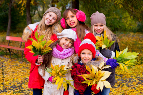 group of girls in autumn park with leafs