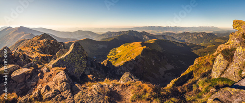 Fototapeta Naklejka Na Ścianę i Meble -  Evening Mountain Landscape with Rocks in Foreground. View from Mount Dumbier in Low Tatras National Park Towards High Tatras Mountains in Slovakia.