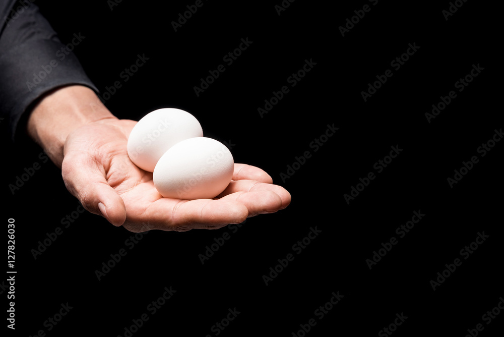 Close up of mans hand holding two eggs Close up of mans hand holding two eggs