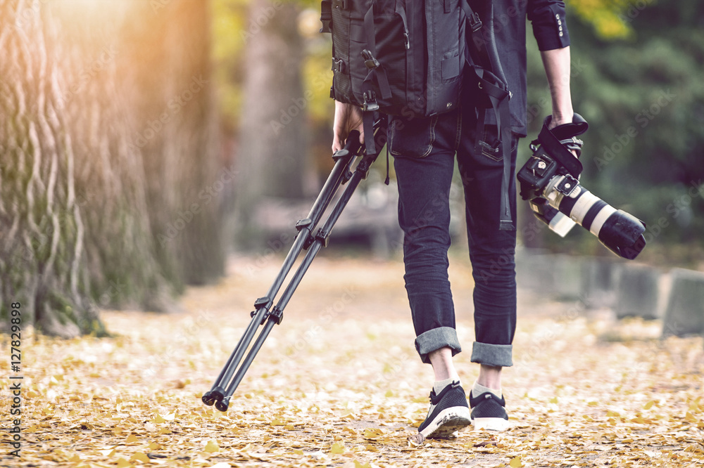 professional photographer with camera and tripod in autumn. Vintage tone. - obrazy, fototapety, plakaty 