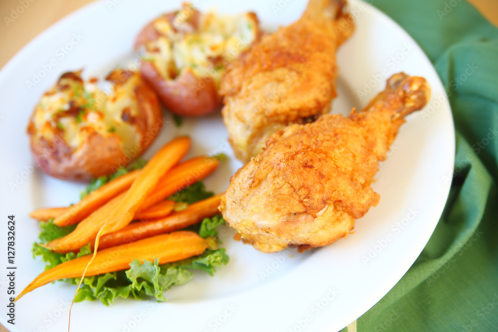 Two fried chicken legs with smashed potatoes and carrots Two fried chicken legs with smashed potatoes and carrots