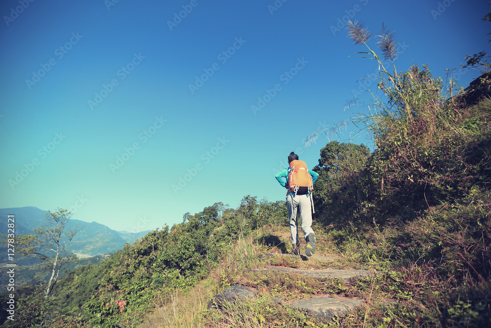 young woman backpacker trekking at mountain peak