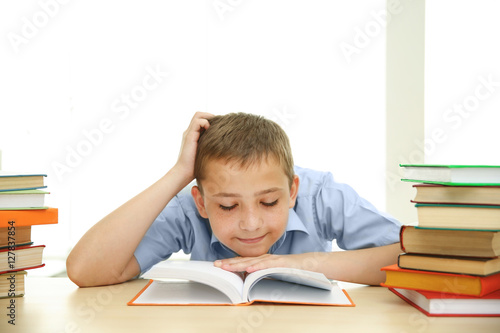Smiling boy with many books...