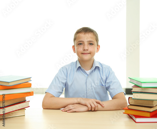 Smiling boy with many books...