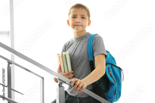 Cute schoolboy with books o...