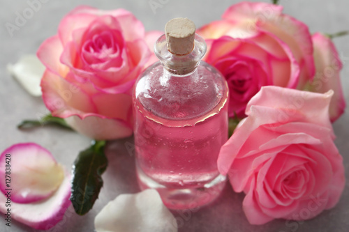 Bottle of aroma oil with roses, closeup