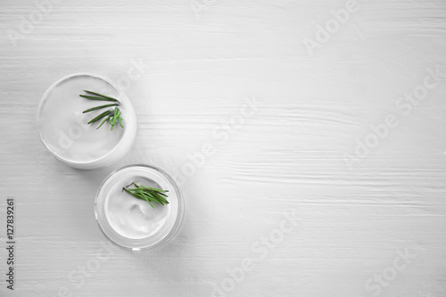 Cream and rosemary on wooden background