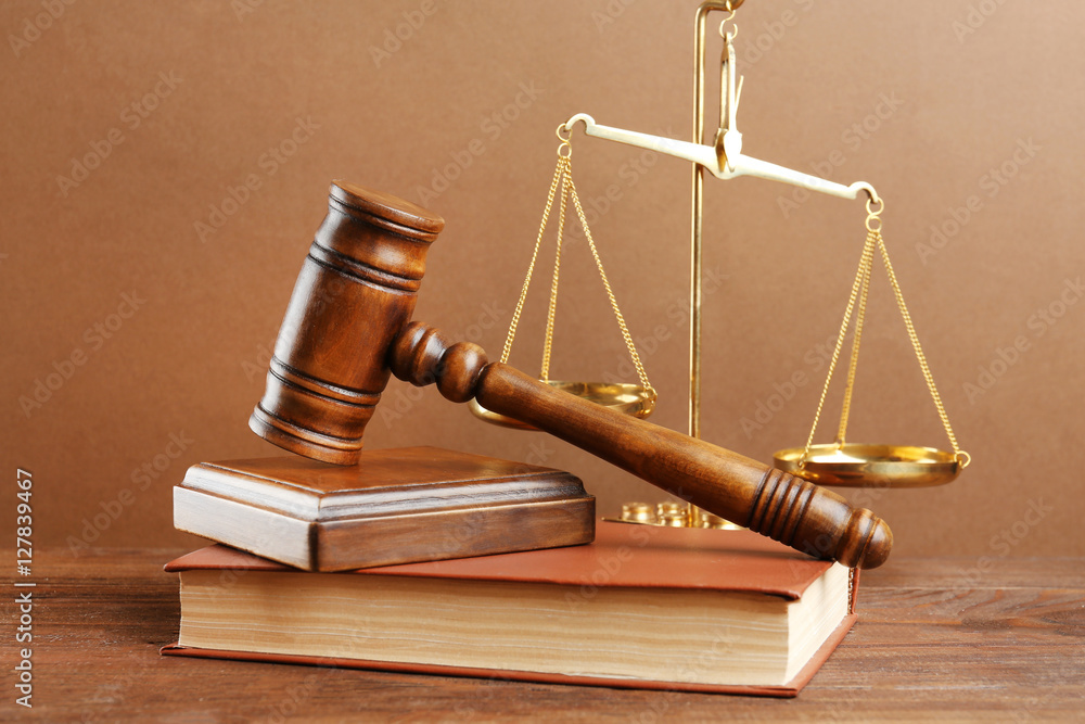 Judge's gavel and scales on brown background Judge's gavel and scales on brown background