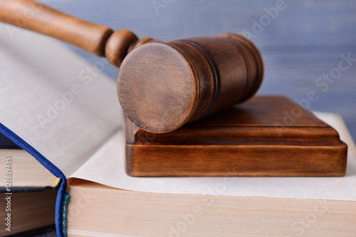 Judge's gavel and books on wooden wall background