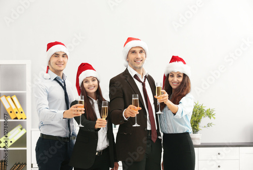 Business people in Santa hats at office party