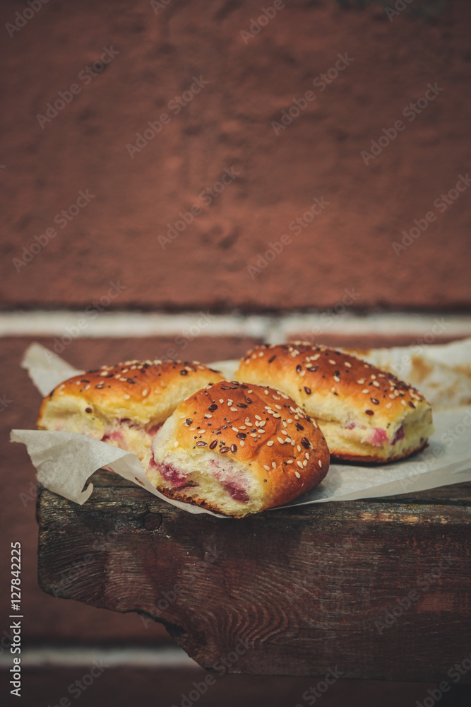 sweet buns with jam on a wooden background sweet buns with jam on a wooden background