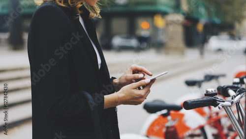 Photography Young businesswomen in black  suit and umbrella using smartphone, biking and goi