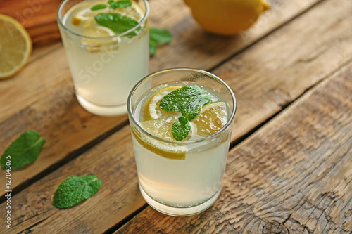 Glass of refreshing lemonade on table