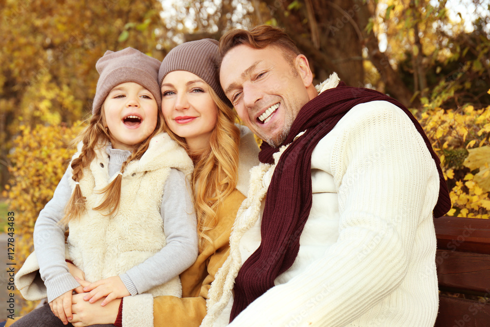 Happy family sitting on bench in beautiful autumn park Happy family sitting on bench in beautiful autumn park