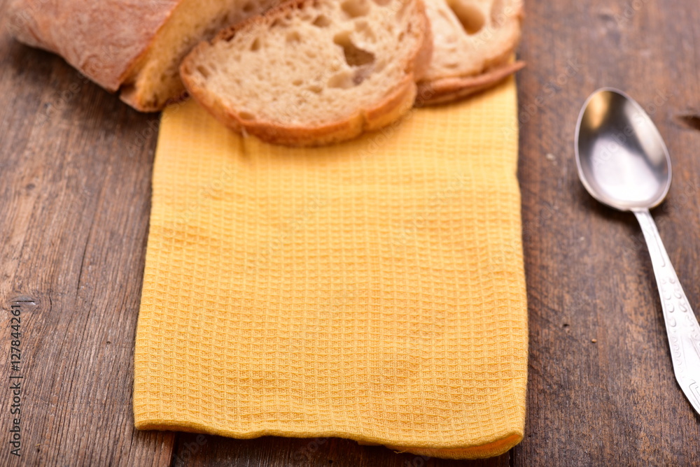 Homemade sliced bread with yellow napkin and spoon on wooden table. Homemade sliced bread with yellow napkin and spoon on wooden table.