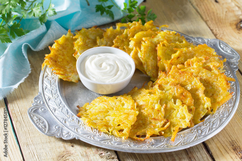 Homemade traditional potato pancakes, served with sour cream sau photo