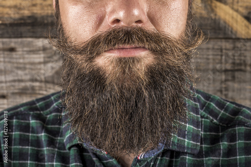 Closeup of a man beard and mustache over wooden background