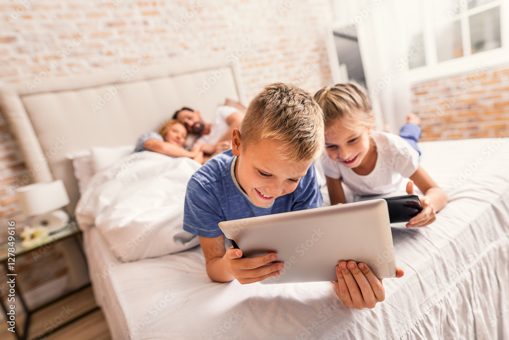 Children enjoying movie on digital gadgets