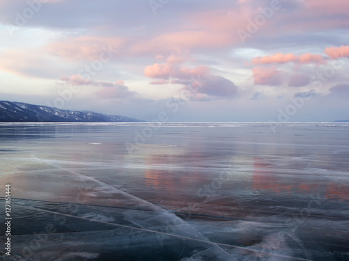 Pink sunset clouds and the ice surface of lake Baikal
