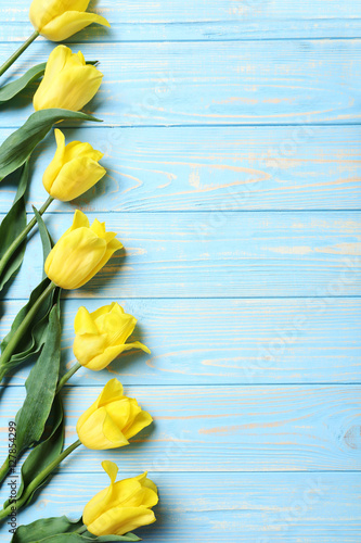 Fototapeta Naklejka Na Ścianę i Meble -  Bouquet of yellow tulips on a blue wooden table
