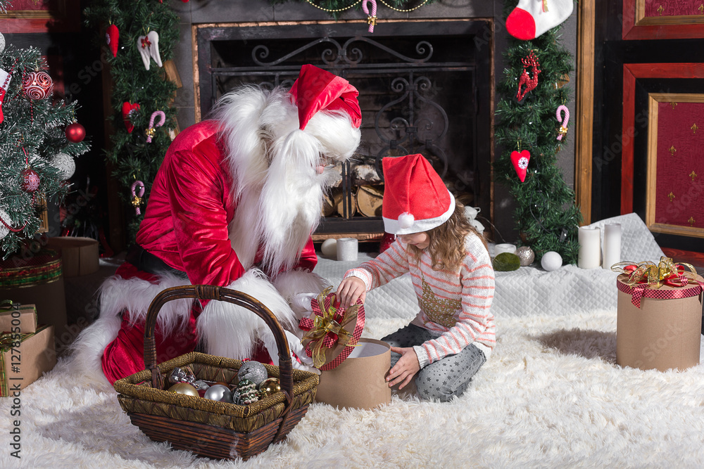 Obraz premium Santa Claus and cute girl getting ready for Christmas.