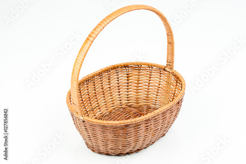 Empty wooden woven fruit or bread basket on white background. Wicker basket. Plaited container. Pink/red color. Top, side view. 