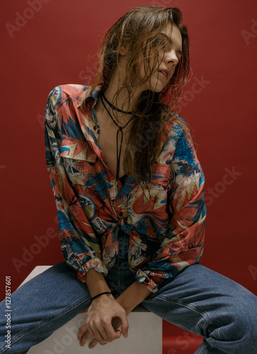 portrait of happy young woman, posing in color shirt and blue je photo