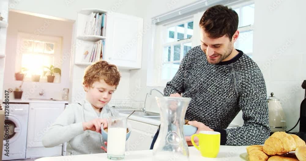 Father and son having a breakfast in kitchen Father and son having a breakfast in kitchen