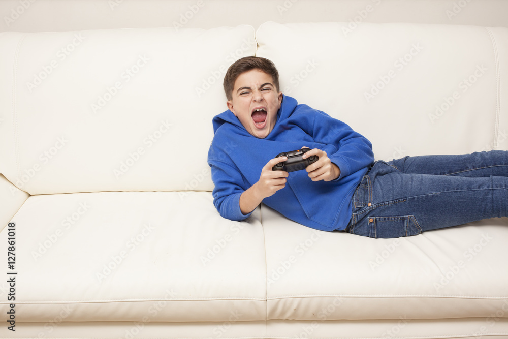 little boy playing videogame on the couch