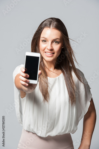 Portrait of smiling young business woman holding a phone