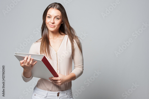 Portrait of smiling young business woman holding a folder