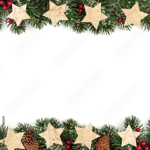 Christmas double border of branches with rustic wood tree ornaments over a white background