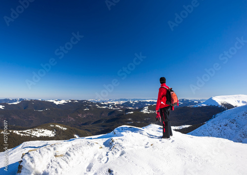 Young happy traveler hiking in beautiful mountains. Fantastic winter landscape