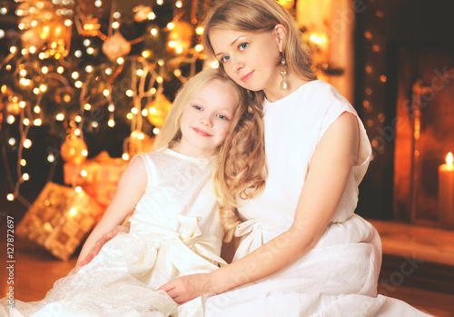 happy mother and child near christmas tree with fireplace home