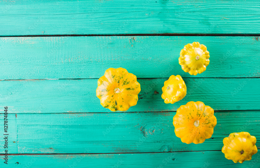 Fototapeta premium Yellow squash on a wooden turquoise background. Top view, Colorful festive still life. Copyspace. 