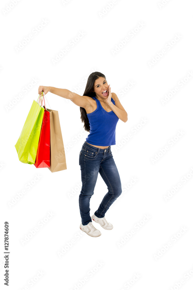 young happy and beautiful hispanic woman holding color shopping bags smiling excited isolated