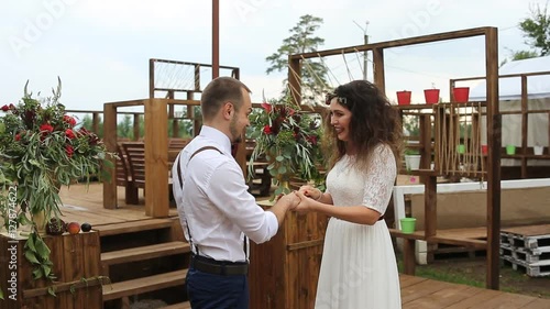 Gentle beautiful bride puts wedding ring on groom's finger. Concept: wedding rustic.