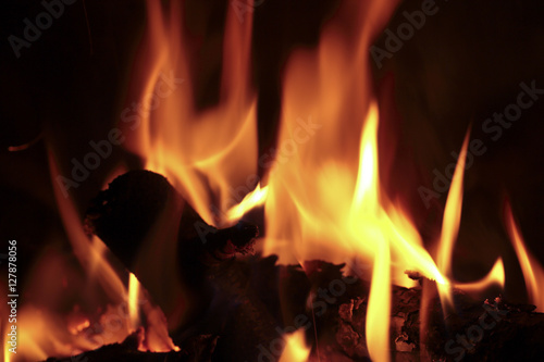 Flames of fire in a fireplace. Shooting horizontal with tones Orange and black.