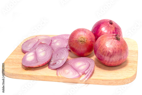 close up of sliced red onion and whole red onion on a wooden tab