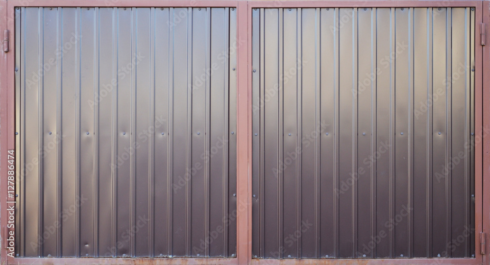 The texture of brown corrugated metal door with a colored frame. The