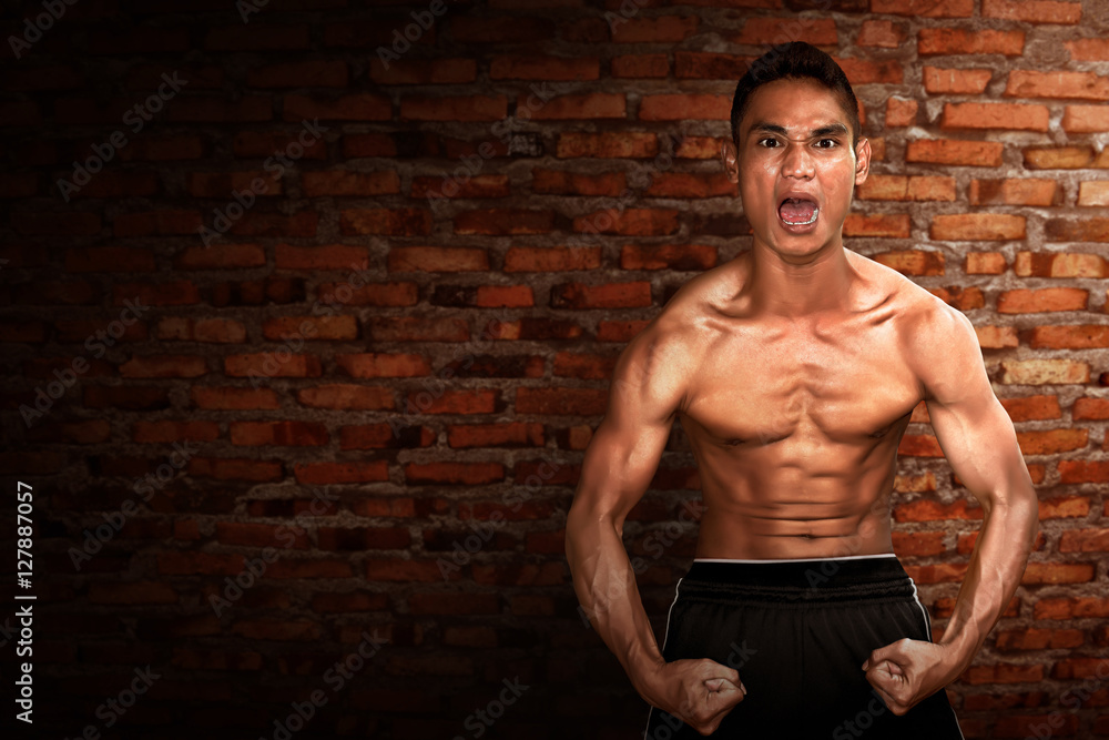 Fototapeta premium Sport man on brick wall background