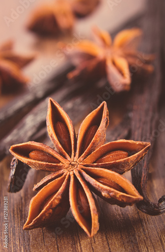 Vintage photo, Closeup of star anise and fragrant vanilla on wooden surface plank