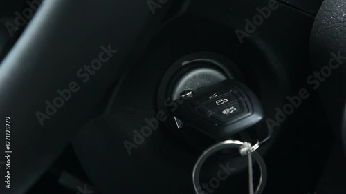Man's hands turning the ignition key in the car
