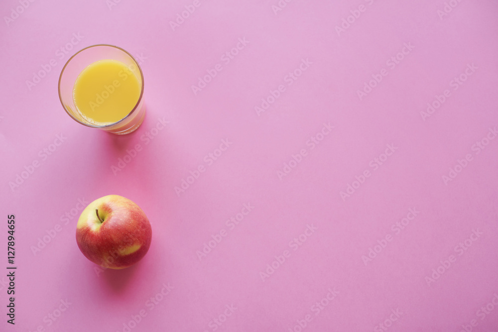 Main view of juice in drinking glass and apple