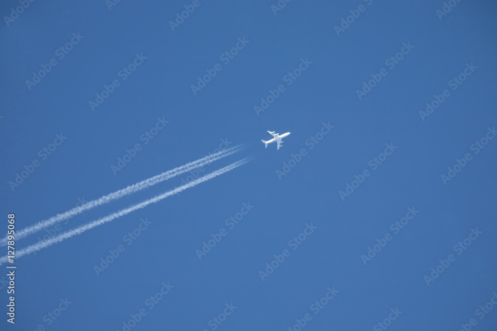 white jet airplane flying high in the blue sky white jet airplane flying high in the blue sky