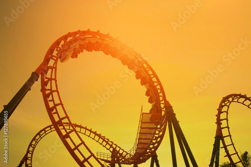 Fototapeta Naklejka Na Ścianę i Meble -  blurred Roller coaster ride in amusement park at evening