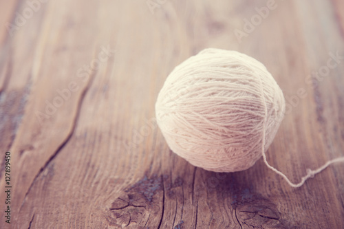 White yarn for knitting on a rustic wooden table