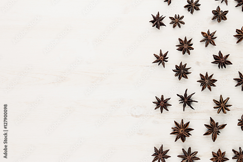 Anise stars spice pattern  on white wood background. Christmas decorative frame. Top view.