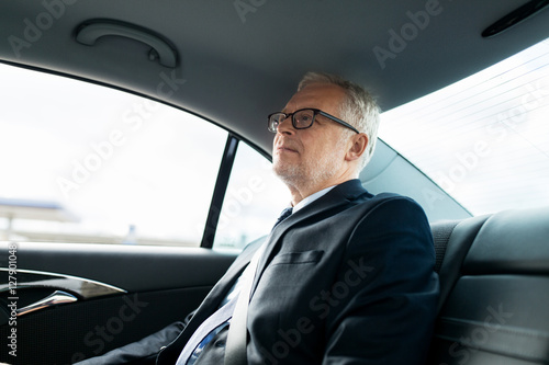senior businessman driving on car back seat
