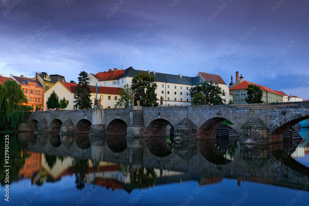 Gothic medieval stony bridge on Otava river. Oldest bridge historical town Pisek, South Bohemia, Czech republic, Europe. Beautiful evening twilight in the town with beautiful bridge in Pisek.